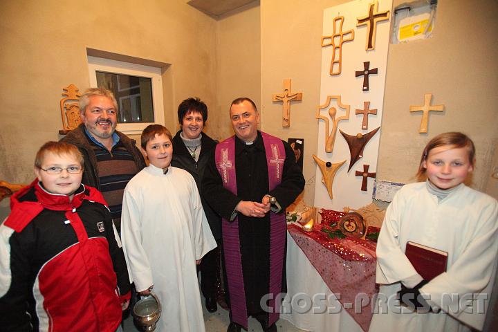 2009.11.28_20.51.24.jpg - Auch die sehr originellen Holz-Exponate, Kruzifixe und Krippen des begabten Schnitzknstlers Herbert Rettensteiner wurden gesegnet.  Am Bild v.l.n.r.: Dominik, Herbert und Rosemarie Rettensteiner mit Sohn Tobias und Helena Krenn als Ministranten mit Pfarrer Mag. Jacek Biela.