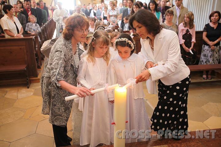 2009.05.21_10.03.30.jpg - Die Klassenlehrerinnen Leichtfried und Gruber helfen beim Anznden der Erstkommunionskerzen an der Osterkerze.