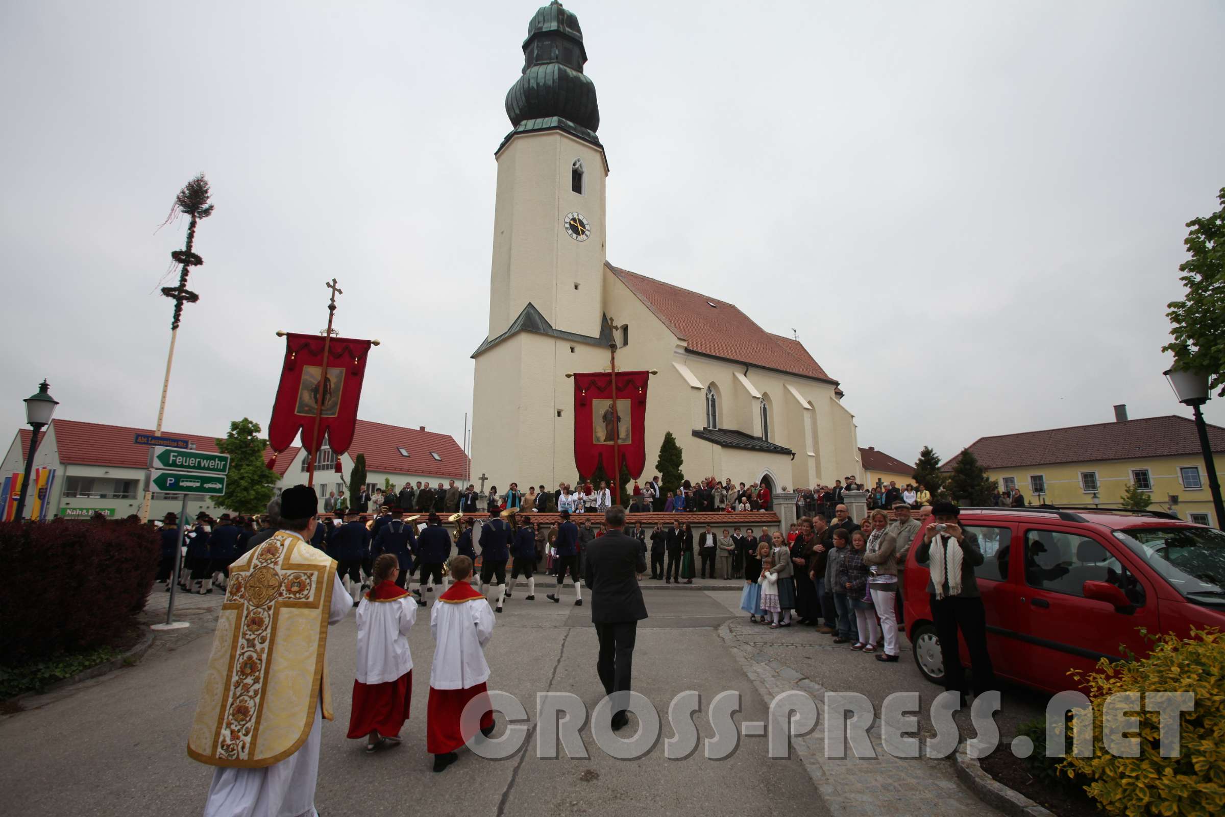 2011.05.01_09.26.13.jpg - Vor der Kirche wie auf der bühne stehen die Eltern, Paten und Verwandten, während die Kinder angeführt von der Blasmusikkapelle und begleitet von Pfarrer P.Jakobus vorbei defilieren.