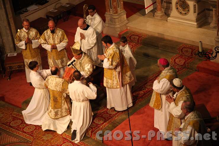 2013.10.06_16.18.02.jpg - Der Bischof überreicht dem Diakon das Evangeliar, aus dem er die Botschaft Jesu Christi verkündigen soll, und besiegelt mit einer abschließenden Umarmung seine Aufnahme in das neue Amt.